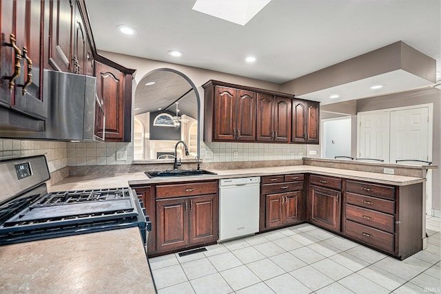 kitchen featuring sink, hanging light fixtures, backsplash, appliances with stainless steel finishes, and light tile patterned floors