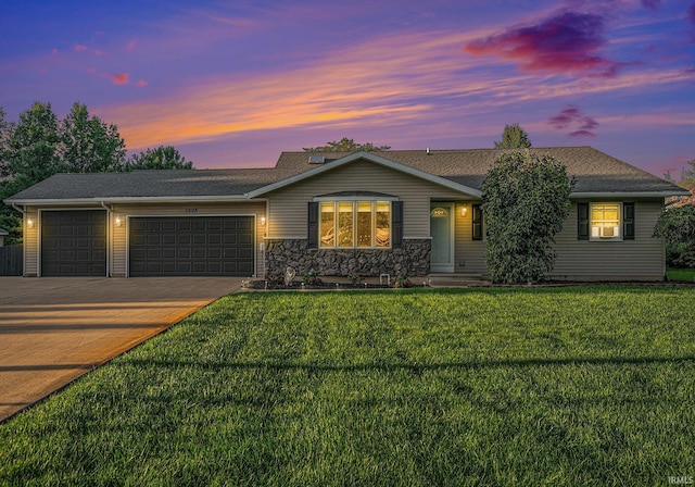 single story home with a garage and a lawn