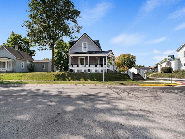 view of front of house with a front yard and a porch