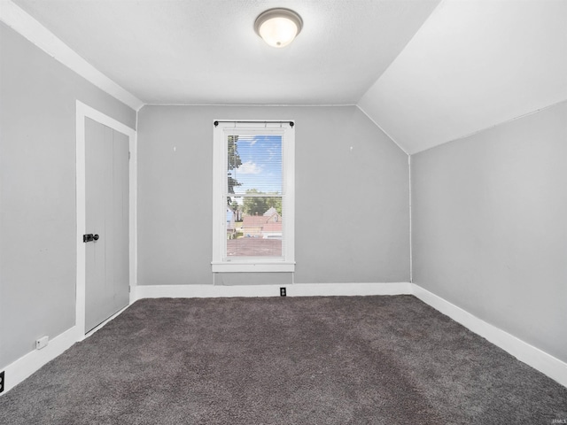 bonus room with vaulted ceiling and carpet flooring