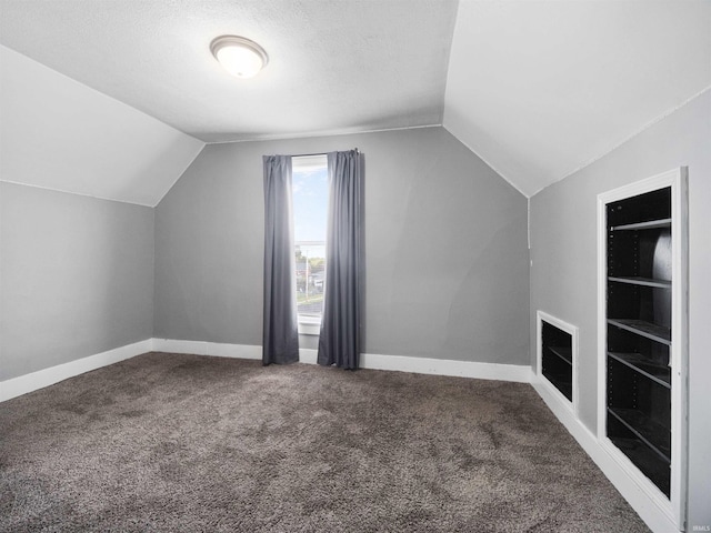 bonus room with a textured ceiling, carpet, and vaulted ceiling