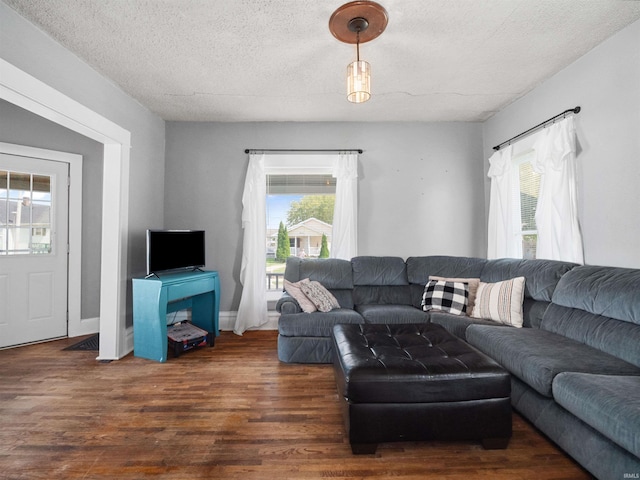 living room with dark hardwood / wood-style floors and a textured ceiling