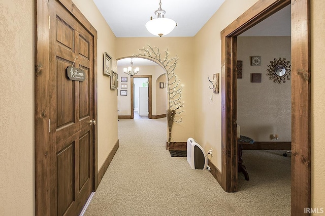 632 W Main St, Peru, IN 46970 - hallway featuring carpet floors, arched walkways, baseboards, and a notable chandelier