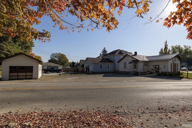 632 W Main St, Peru, IN 46970 - view of front facade featuring an outdoor structure, a chimney, metal roof, a residential view, and a detached garage