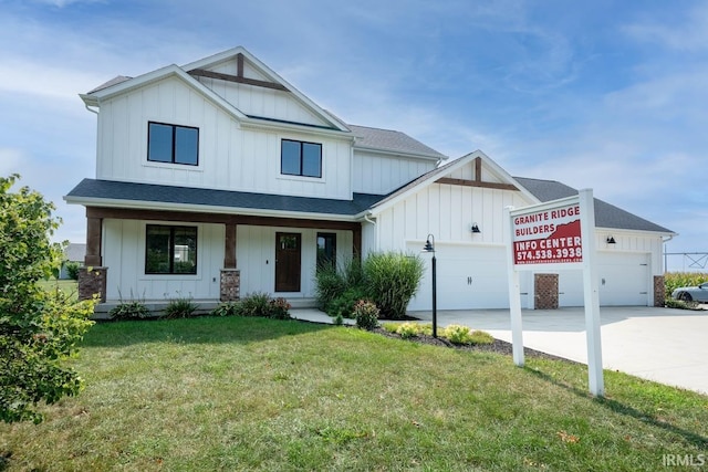 view of front of home with a garage, a front yard, and covered porch