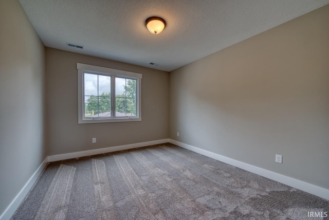 carpeted spare room featuring a textured ceiling