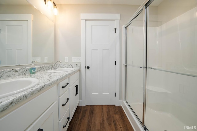 bathroom with walk in shower, hardwood / wood-style flooring, and vanity