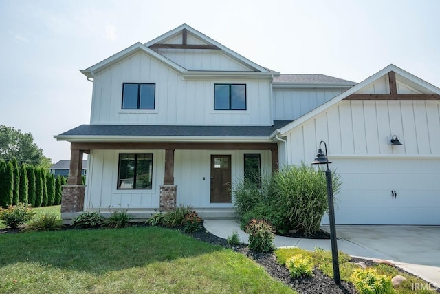 view of front of house with a front lawn, a garage, and covered porch