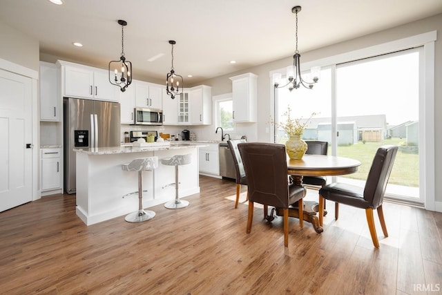 dining area featuring light wood-type flooring and an inviting chandelier