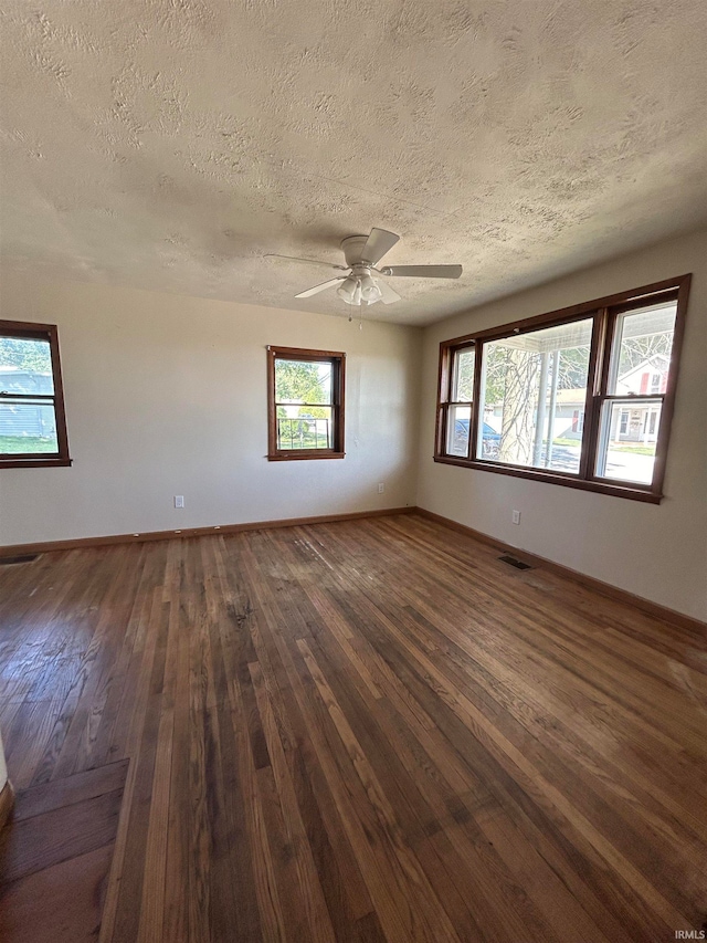 empty room featuring ceiling fan, dark hardwood / wood-style flooring, and a textured ceiling