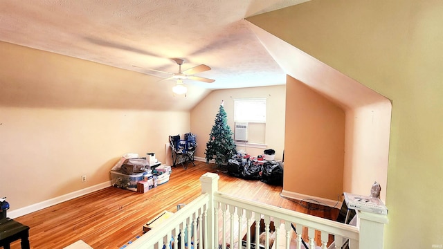 bedroom featuring a textured ceiling, wood-type flooring, ceiling fan, lofted ceiling, and a nursery area