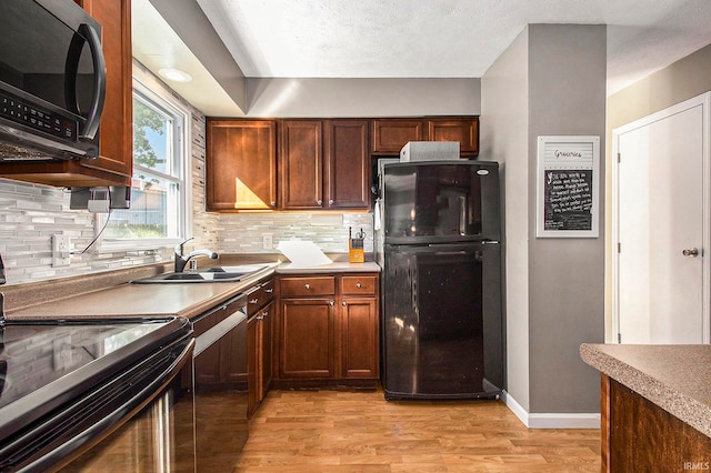 kitchen with light hardwood / wood-style flooring, sink, appliances with stainless steel finishes, and decorative backsplash