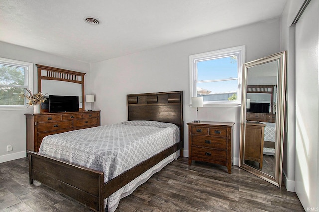 bedroom featuring dark hardwood / wood-style floors and multiple windows