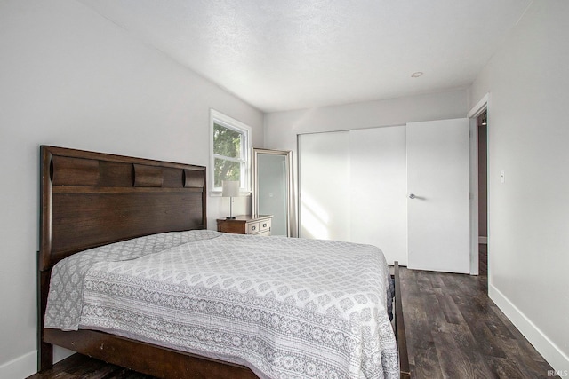 bedroom featuring a closet, a textured ceiling, and dark hardwood / wood-style floors