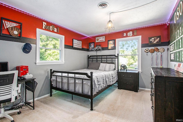 carpeted bedroom featuring multiple windows and a textured ceiling