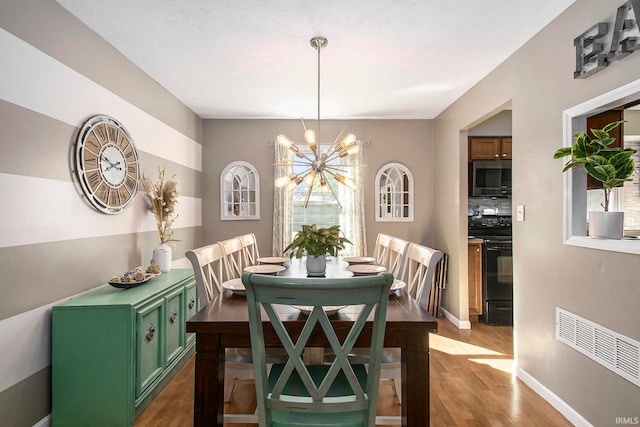 dining space with a notable chandelier and hardwood / wood-style flooring