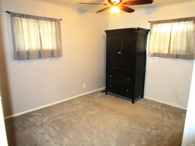 unfurnished bedroom featuring ceiling fan, light carpet, and multiple windows