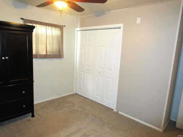 unfurnished bedroom featuring carpet flooring, ceiling fan, and a closet