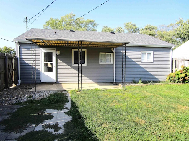 rear view of house featuring a yard