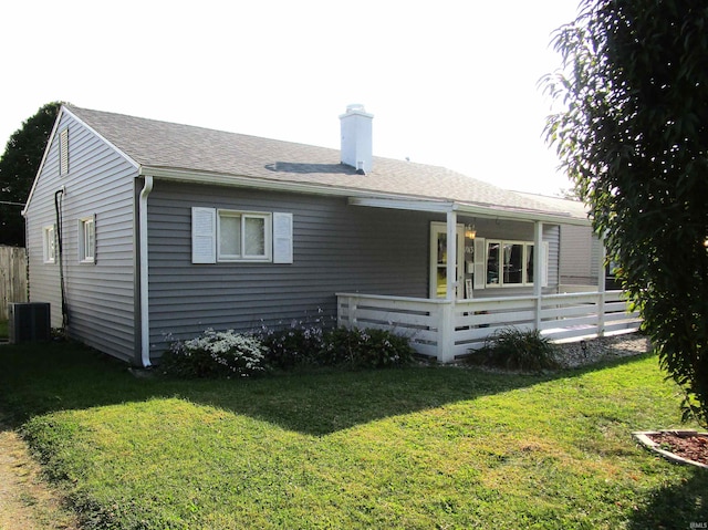 rear view of property with a yard and central AC unit