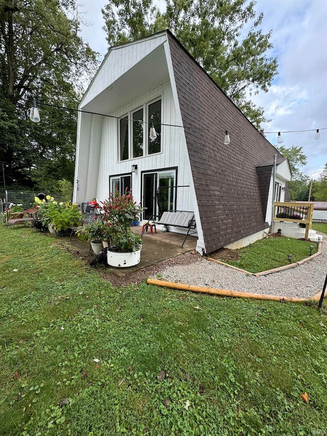 rear view of property featuring a yard and a patio area