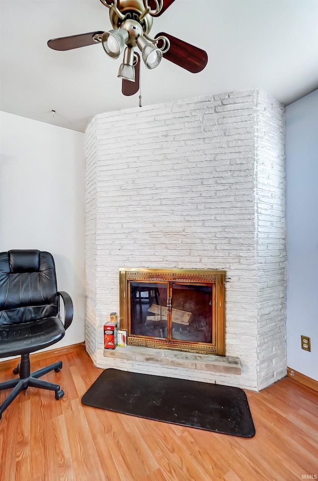 interior space with ceiling fan, wood-type flooring, and a fireplace