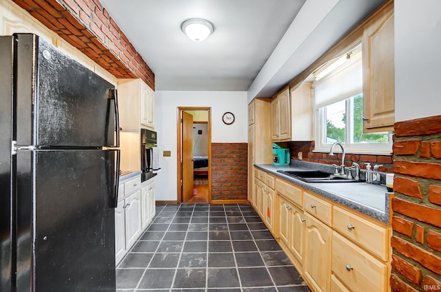 kitchen with black appliances, light brown cabinets, dark tile patterned floors, and sink