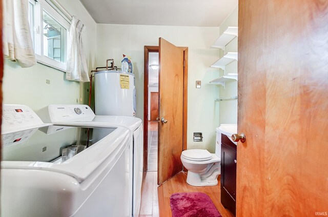 laundry room featuring light hardwood / wood-style flooring, water heater, and washer and dryer