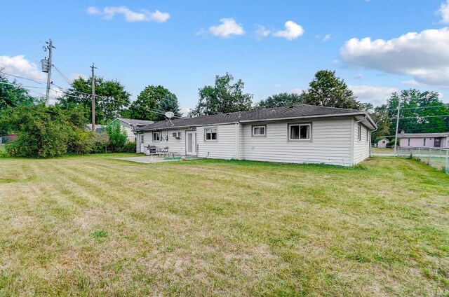 rear view of property with a yard and a patio area