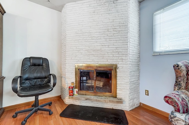 sitting room featuring hardwood / wood-style floors and a brick fireplace