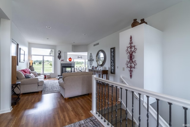 living area featuring wood finished floors, visible vents, recessed lighting, and a multi sided fireplace