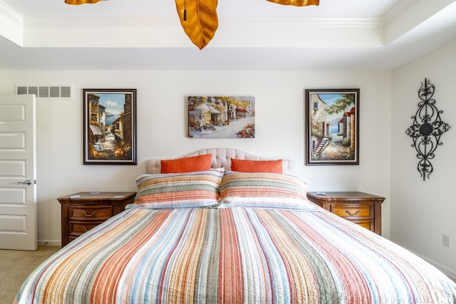 carpeted bedroom featuring visible vents, a tray ceiling, and crown molding