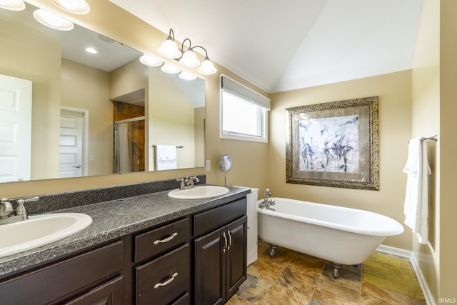 full bath featuring a freestanding tub, a sink, double vanity, and a stall shower