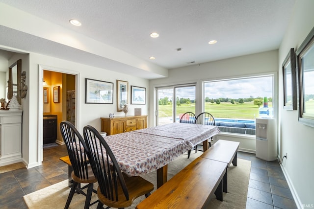 dining space featuring stone tile floors, baseboards, recessed lighting, and a textured ceiling
