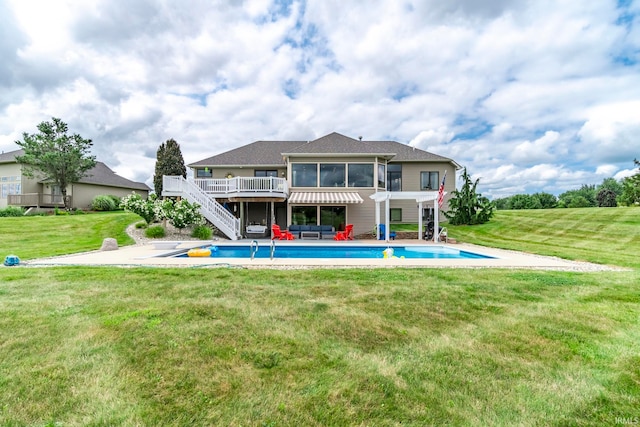 rear view of property with a swimming pool side deck, a lawn, a patio, and a sunroom