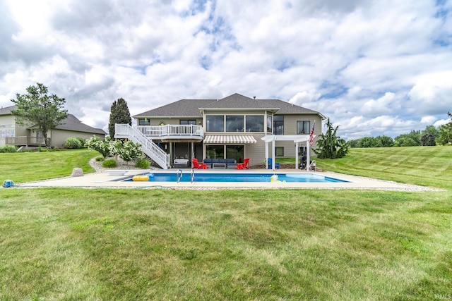 rear view of house featuring stairs, an outdoor pool, a yard, a sunroom, and a deck