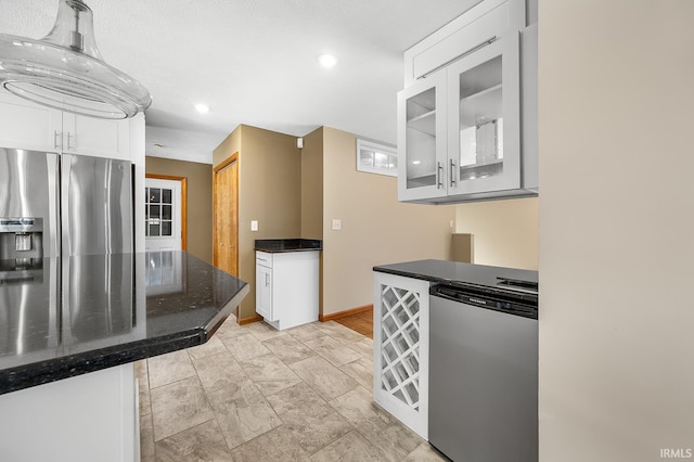 kitchen with dark stone counters, appliances with stainless steel finishes, and white cabinets