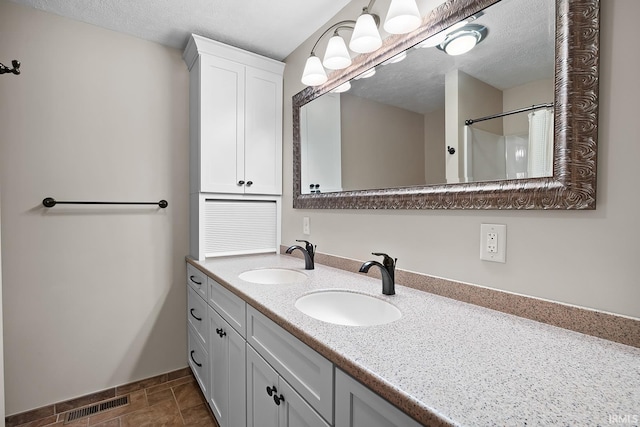 bathroom featuring vanity, a textured ceiling, and a shower