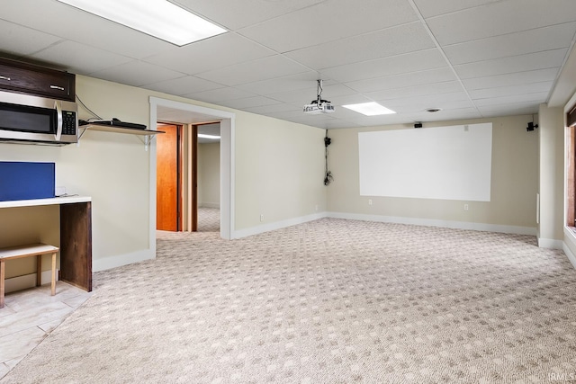 basement featuring light colored carpet and a drop ceiling