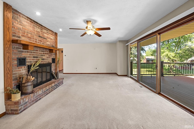 unfurnished living room featuring a fireplace, light carpet, ceiling fan, and a textured ceiling