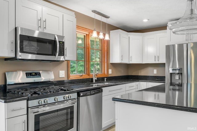 kitchen featuring pendant lighting, stainless steel appliances, sink, and white cabinets