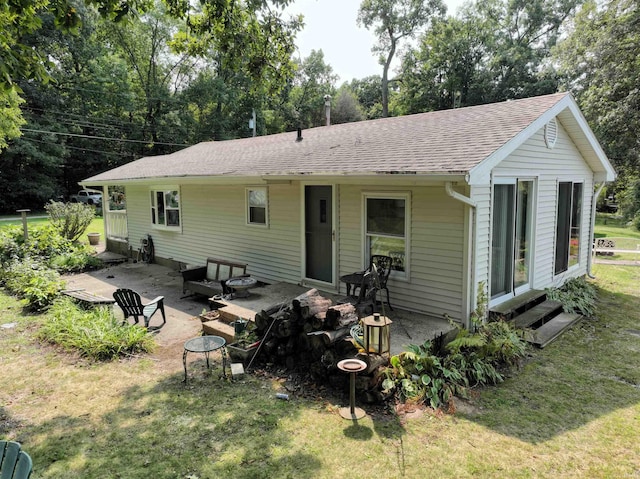 back of house with a lawn and a patio