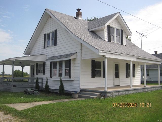 farmhouse featuring a front lawn and covered porch