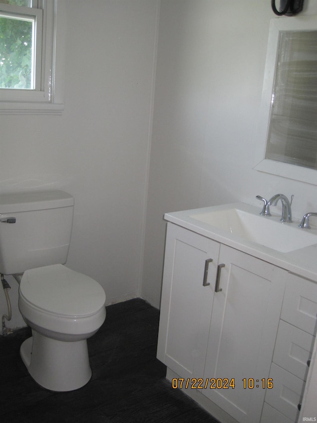 bathroom featuring toilet, hardwood / wood-style flooring, and vanity