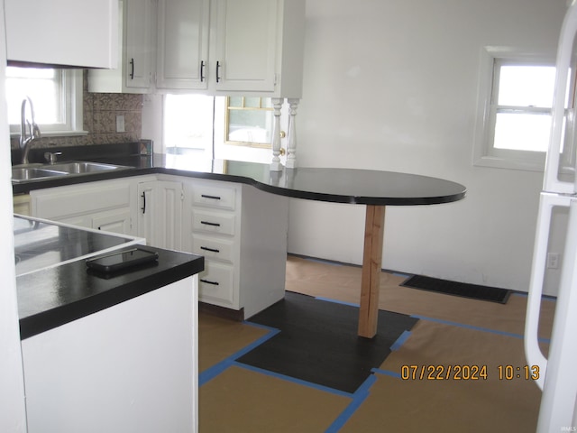 kitchen with white cabinets, backsplash, a wealth of natural light, and sink