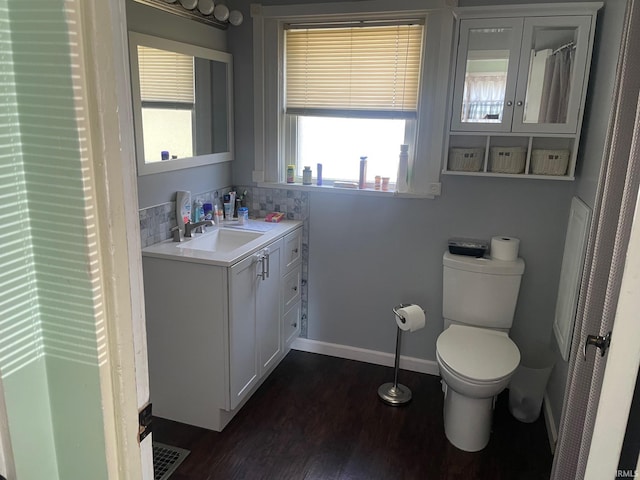 bathroom with vanity, toilet, a wealth of natural light, and wood-type flooring