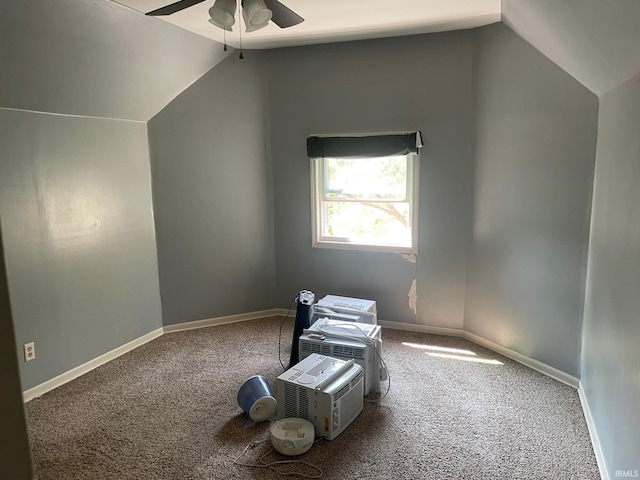 carpeted spare room with ceiling fan and vaulted ceiling