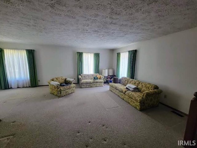 unfurnished living room featuring carpet flooring and a textured ceiling