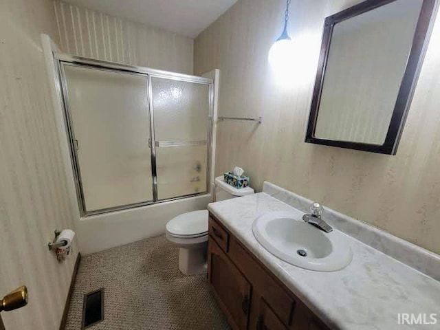 full bathroom with vanity, toilet, and shower / bath combination with glass door