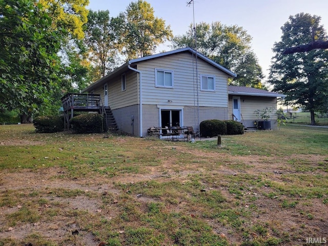 rear view of property featuring central AC unit, a deck, a yard, and a patio